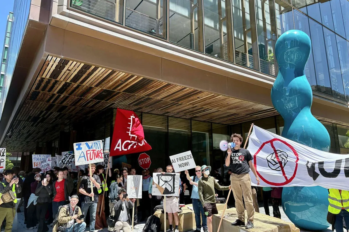 Michaël Trazzi addresses protesters through a megaphone outside OpenAI’s Mission Bay headquarters